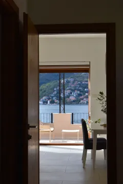 Pogled iz prostorije kroz otvorena vrata prema terasi i moru. - image 2