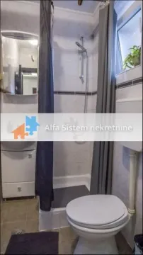 Smaller bathroom with a shower cabin, washbasin, and toilet. - image 2