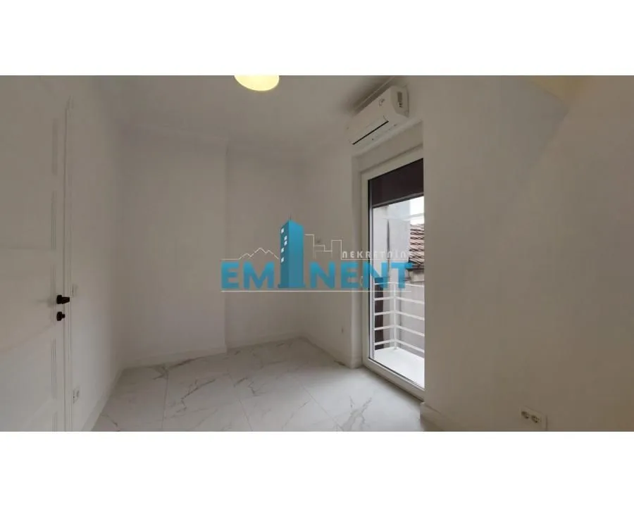 Empty bright room with white walls, marble tiles and access to the terrace.