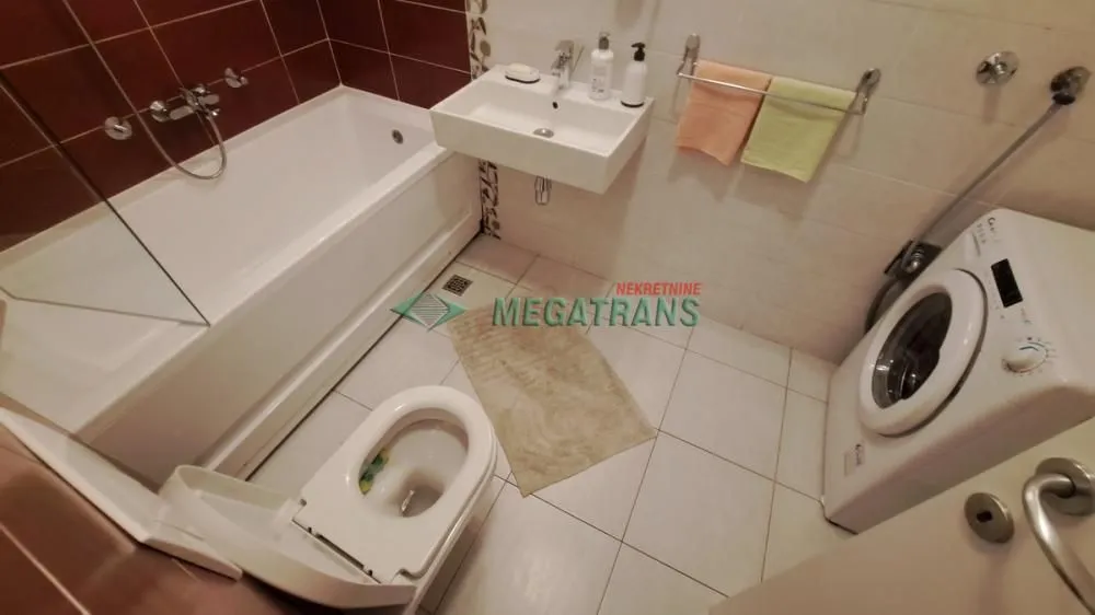 Kupatilo opremljeno kadom, umivaonikom, WC šoljom i veš mašinom.