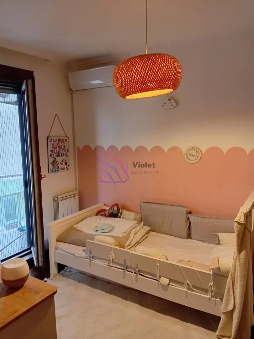 Dječija soba sa krevetom i visećom lampom.