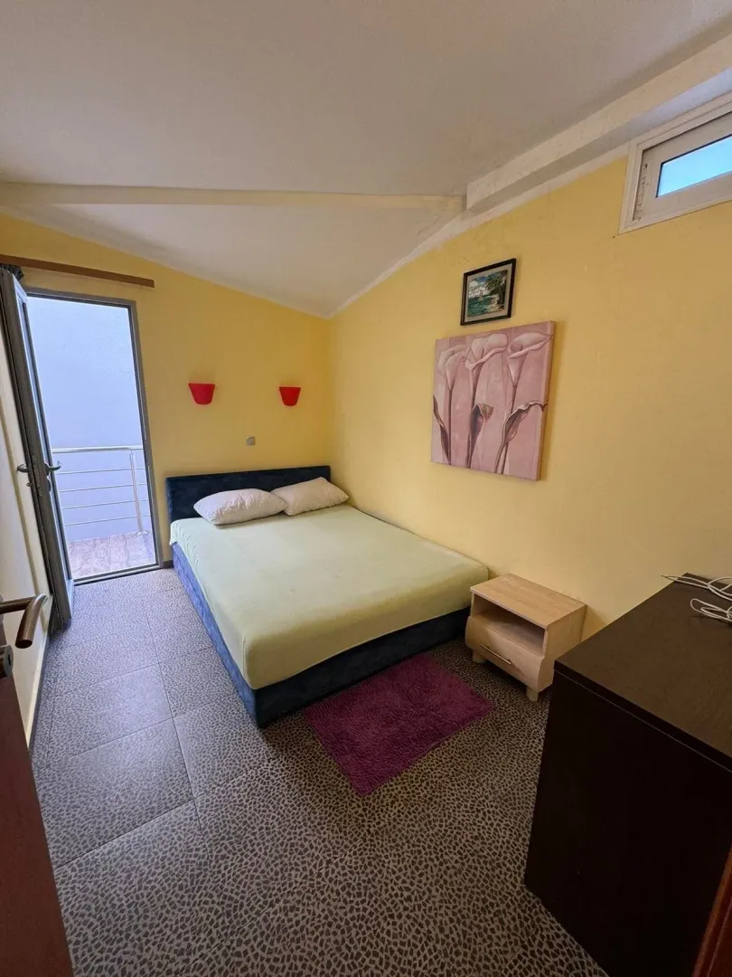 Spavaća soba sa bračnim krevetom i izlazom na terasu.