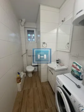 Manje kupatilo sa belim pločicama, umivaonikom, WC šoljom i veš mašinom. - image 8