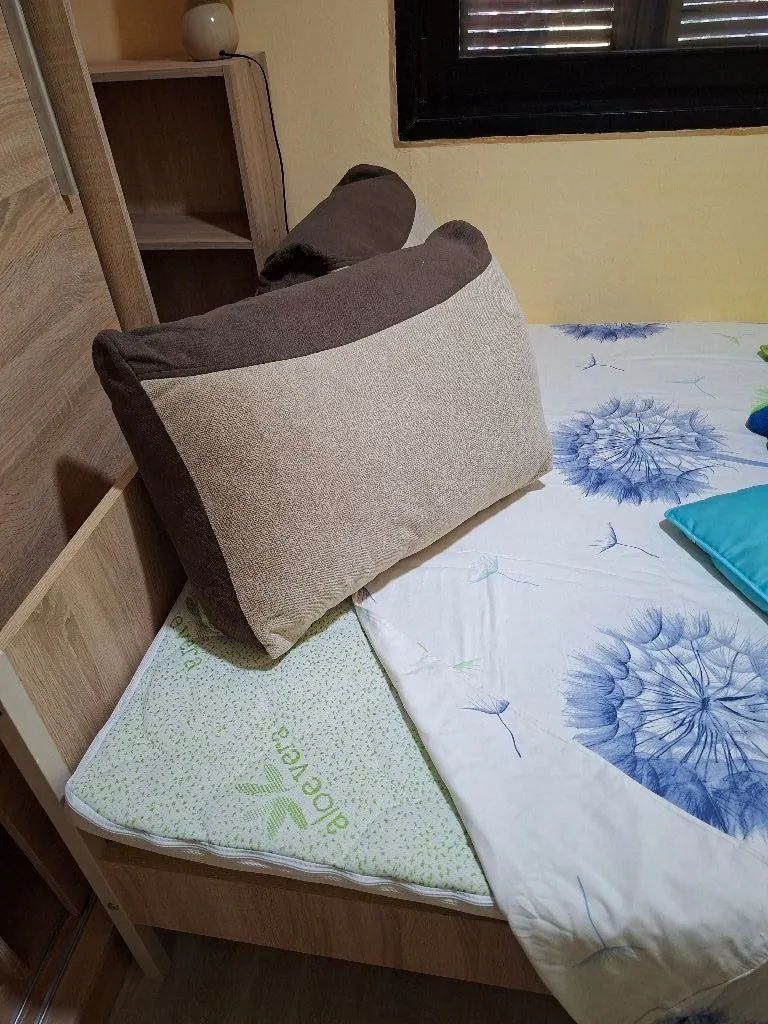 View of a bed with pillows in a bedroom.