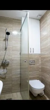 Manje kupatilo sa tuš kabinom, WC šoljom i zidnim ormarićem. - image 7
