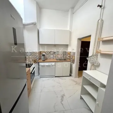 Small kitchen with white cabinets, a sink, and built-in appliances. - image 7