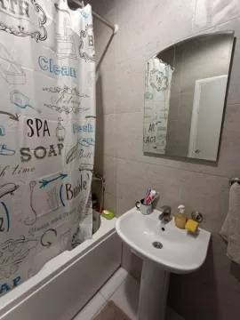 Compact bathroom with a sink, mirror, and bathtub with a curtain. - image 10