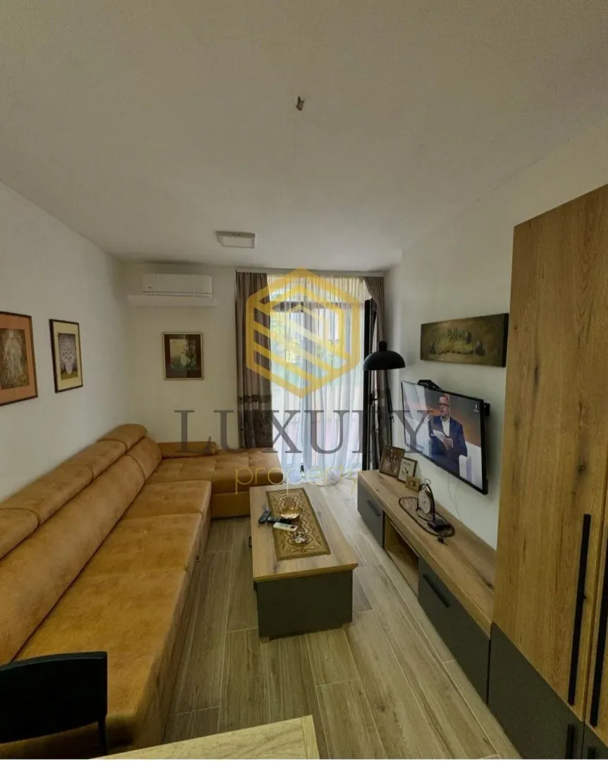 Dnevna soba sa garniturom, televizorom i klub stočićem.