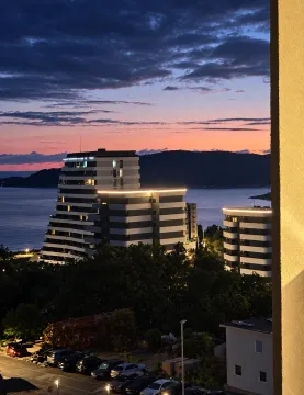 View from the terrace towards the buildings and the sea at dusk. - image 2