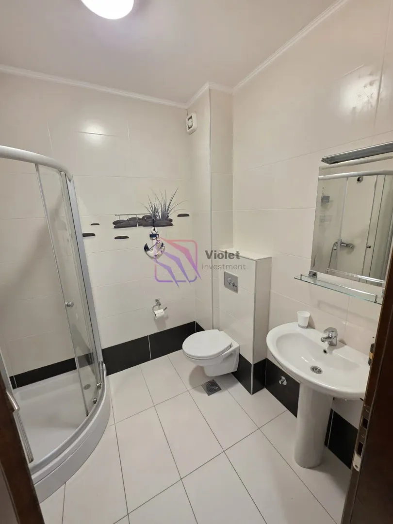 Compact bathroom with a shower cabin, washbasin, and toilet.