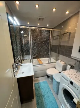 Svijetlo i moderno kupatilo sa kadom, lavaboom i veš mašinom. - image 8