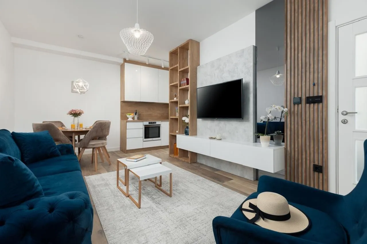 Living room with sofa, TV and dining area.