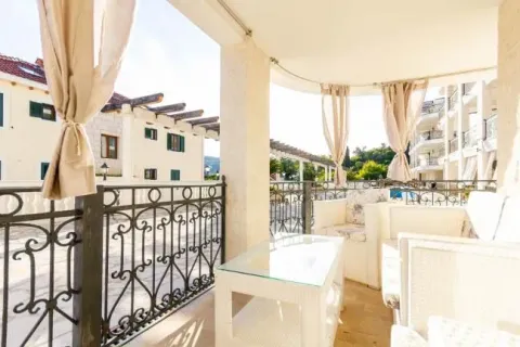Spacious covered terrace with seating furniture and a view of surrounding buildings. - image 9