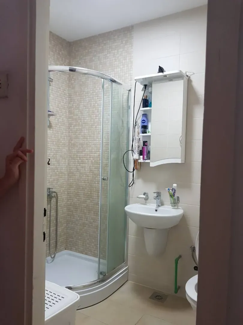 Simple bathroom with a shower cabin and sink.