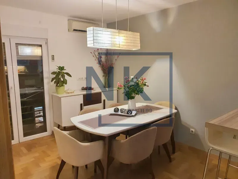 Dining area with a table, chairs, and a chandelier.