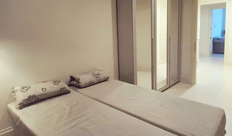 Spavaća soba sa dva kreveta i ugradnim ormarom sa ogledalima. - image 14