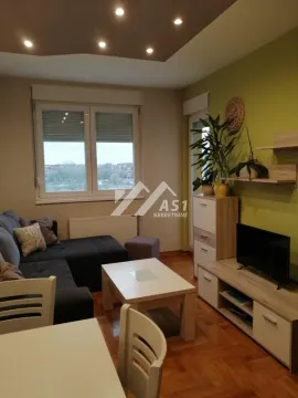 Nameštena dnevna soba sa garniturom za sedenje, televizorom i trpezarijskim stolom. - image 3