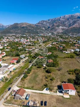 Pogled iz vazduha na okolinu i naselje sa planinama u pozadini. - image 8