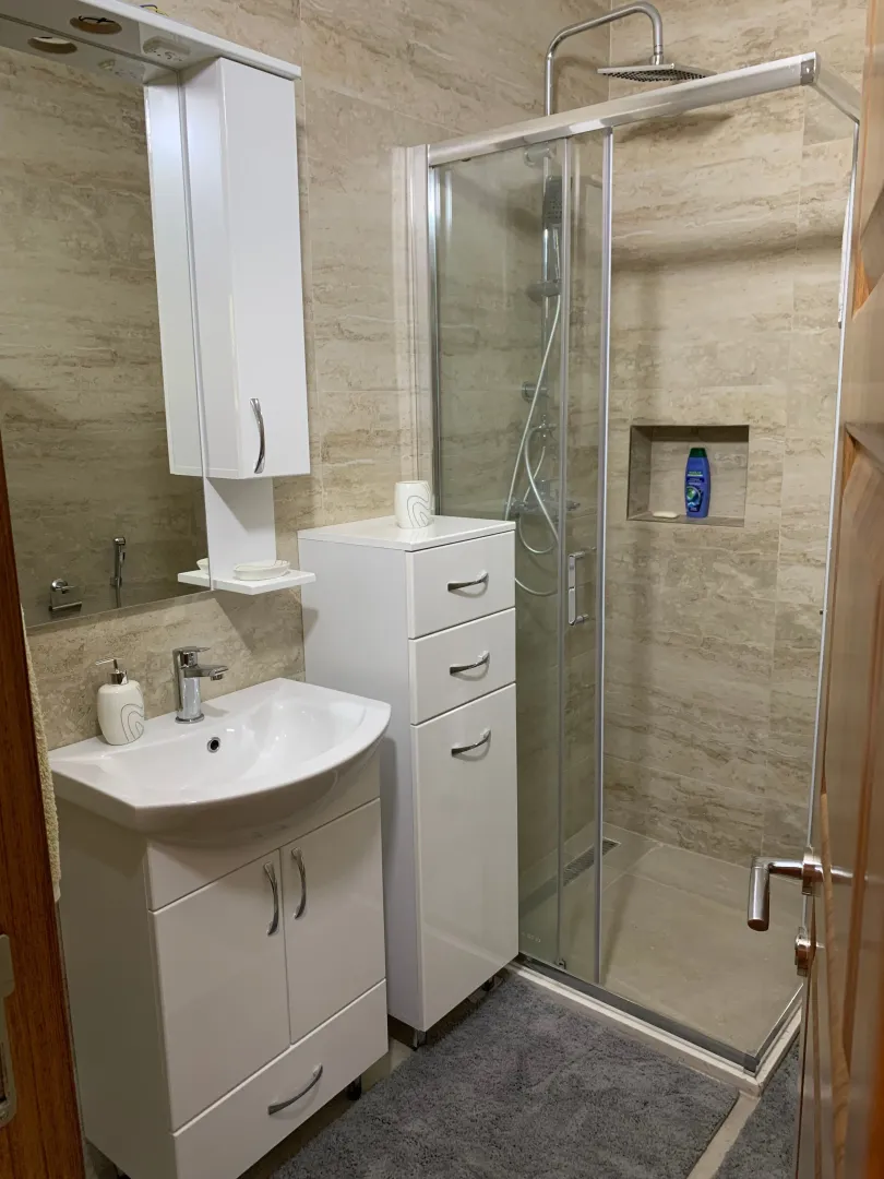 Bathroom equipped with a washbasin, mirrored cabinet, and a shower cabin.