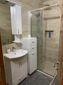 Bathroom equipped with a washbasin, mirrored cabinet, and a shower cabin. - image 8