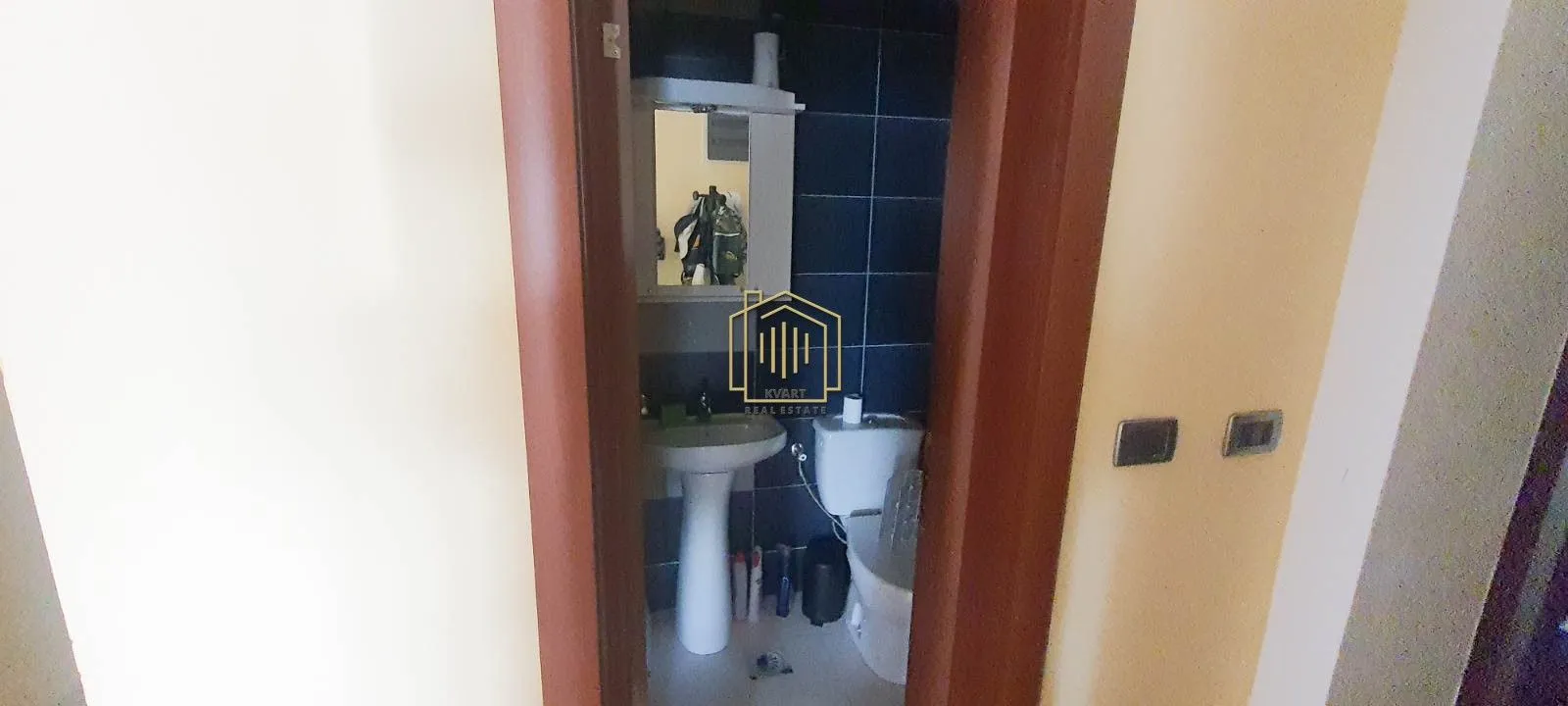 View through the doorway into a small bathroom with a sink and toilet.