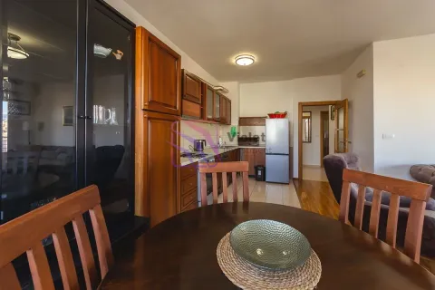 Kuhinja opremljena drvenim elementima sa trpezarijskim stolom u prvom planu. - image 7