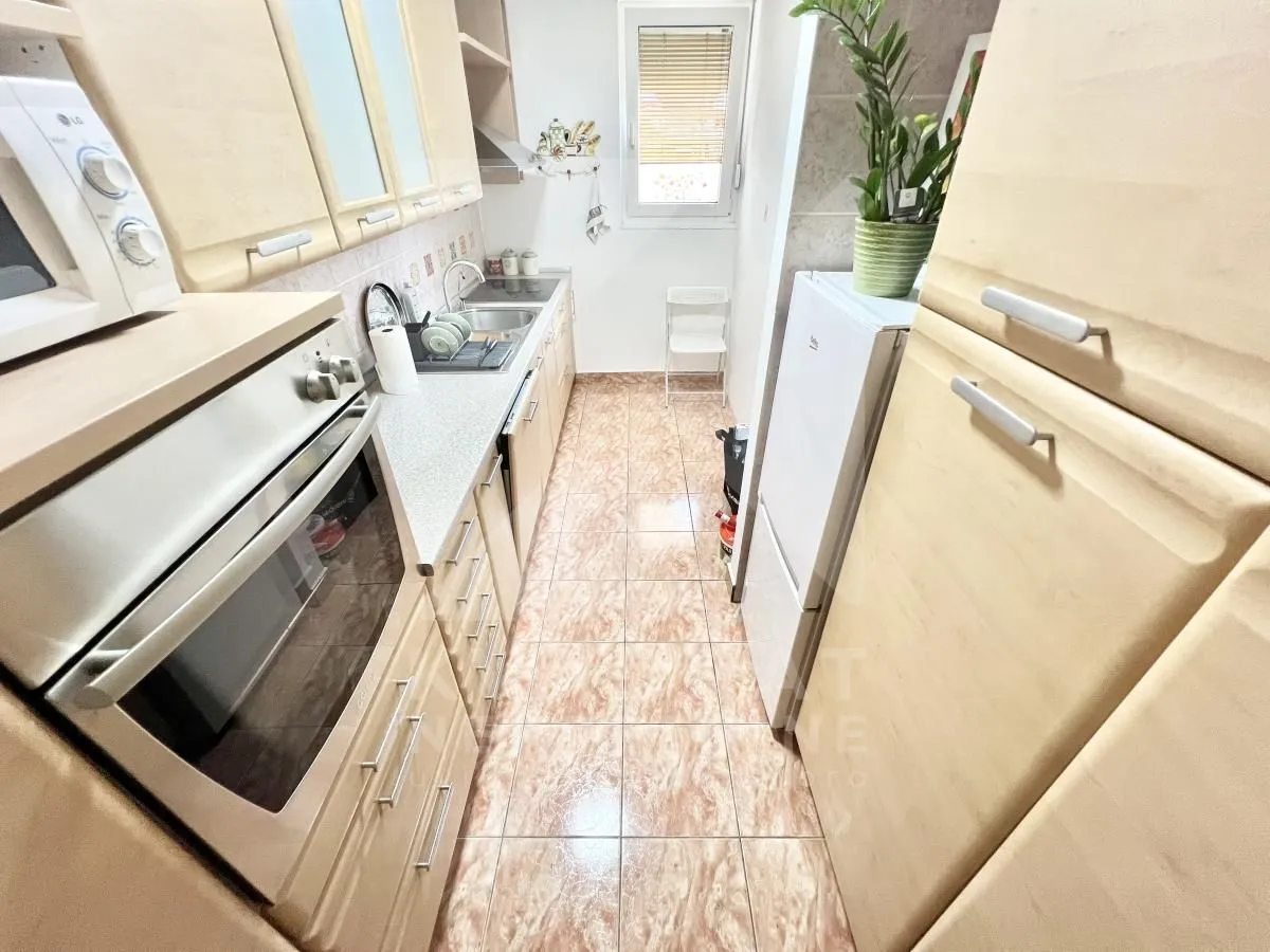 Small kitchen with light wood cabinetry and a built-in oven.