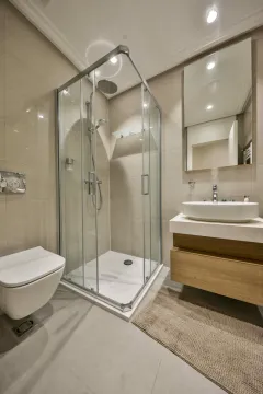 Savremeno opremljeno kupatilo sa tuš kabinom, umivaonikom i WC šoljom. - image 2