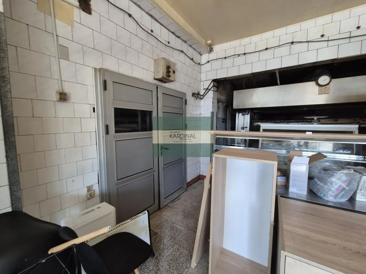 View of a part of an old kitchen or workspace with wall tiles and metal doors.