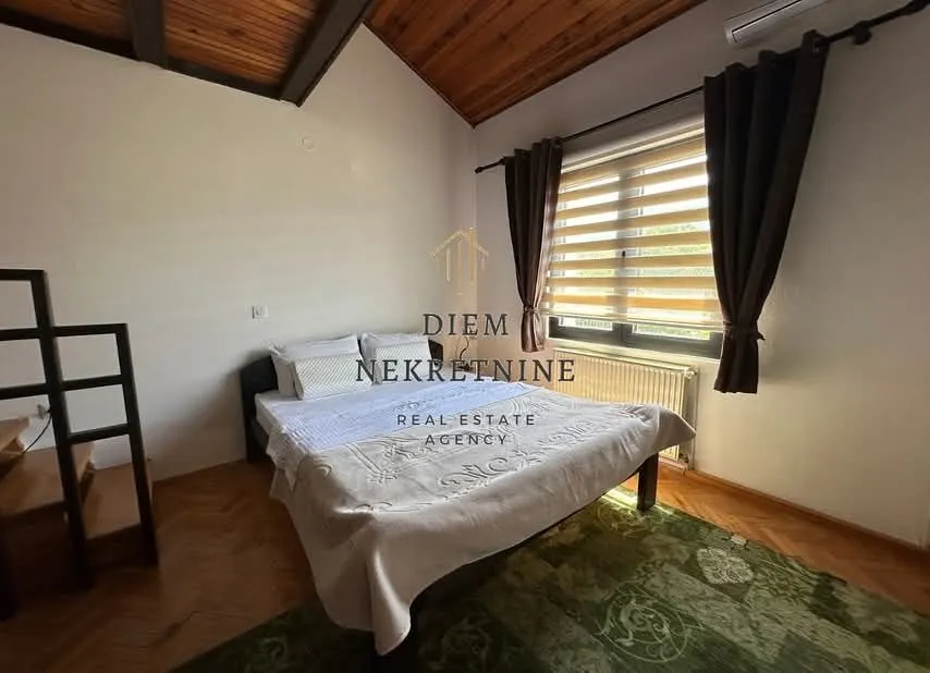 Bedroom with a double bed, wooden ceiling, and a window.