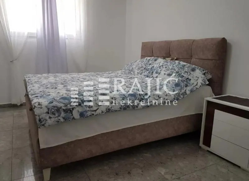 Furnished bedroom with a double bed and a nightstand.