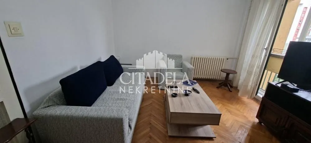 Living room with sofa, coffee table, and television.