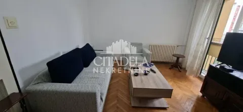 Living room with sofa, coffee table, and television. - image 2