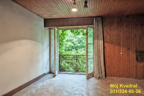 Prazna prostorija sa drvenim plafonom i balkonskim vratima koja gledaju na zelenilo. - image 12