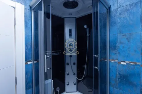 Bathroom with a shower cabin lined with blue tiles. - image 24