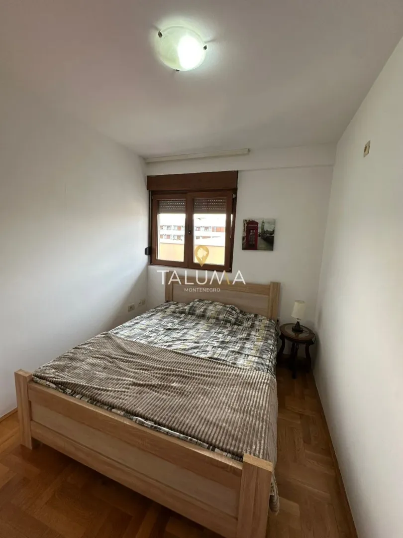 Furnished bedroom with a double bed and a window.