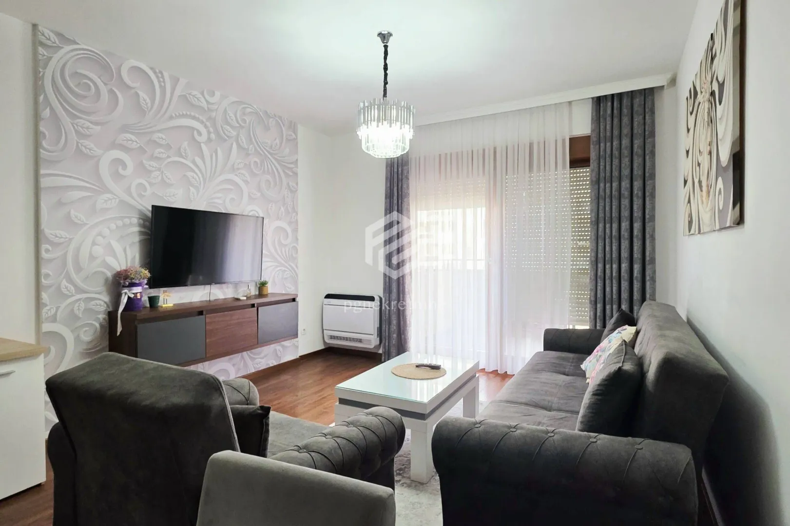 Living room with sofa, TV and access to the terrace.
