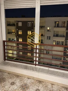 Zastakljena terasa sa pogledom na okolne zgrade u noćnim satima. - image 5