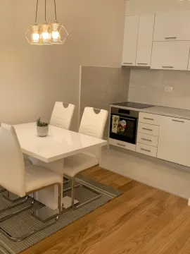 Moderna kuhinja sa trpezarijskim stolom i bijelim elementima. - image 2