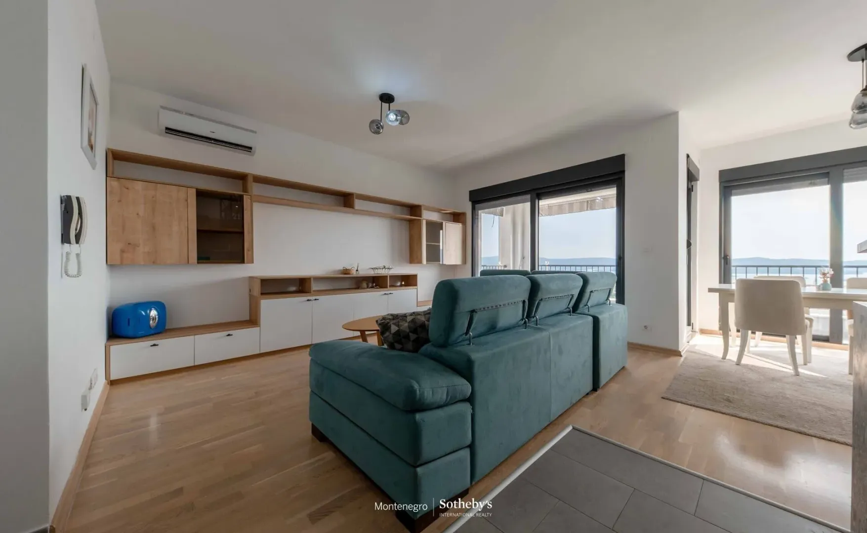 Prostrana dnevna soba sa garniturom i izlazom na terasu.