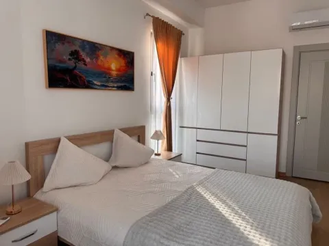 Bright and tidy bedroom with a double bed, wardrobe, and a painting on the wall. - image 4