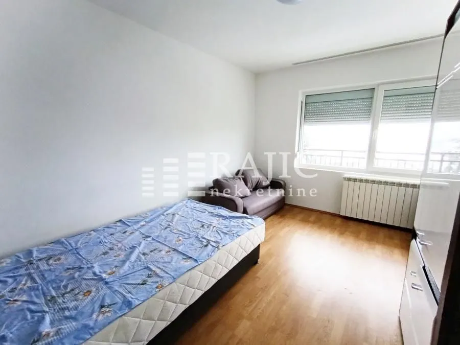 Furnished bedroom with a bed and a window.