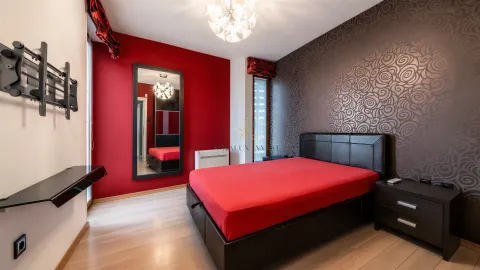 Modern bedroom with a double bed, red accent wall, and decorative wallpaper. - image 10