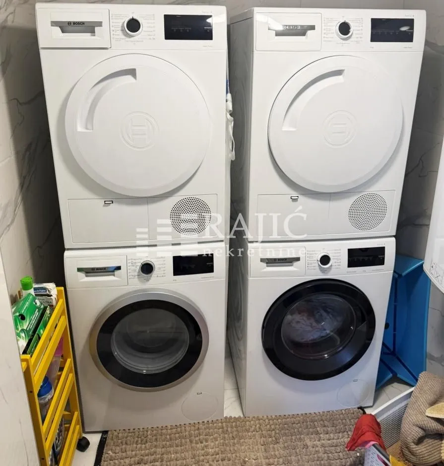 Bathroom with two washing and drying machines.