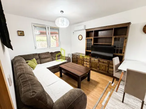 Living room with a sectional sofa, wooden furniture, and a dining table. - image 12