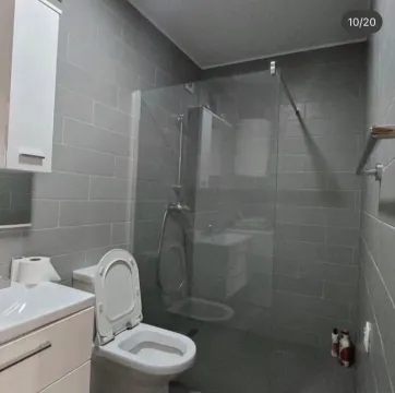 Modernly equipped bathroom with a walk-in shower and grey ceramic tiles. - image 6