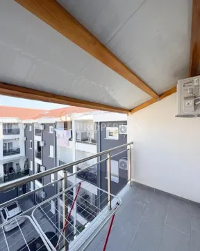 Covered balcony space with metal railing and a view of the building. - image 3