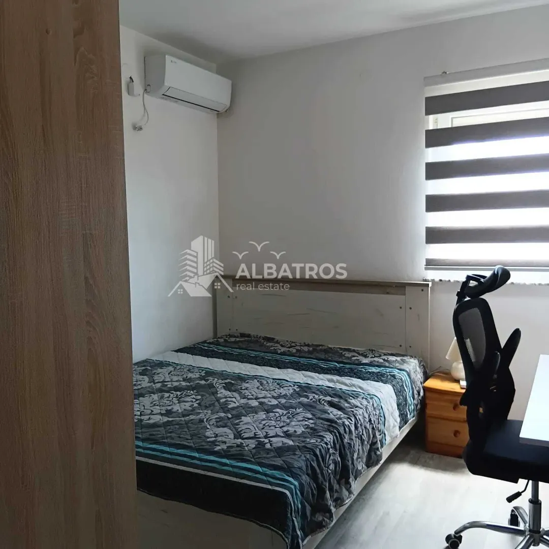 Furnished bedroom with a double bed, desk, and air conditioning.