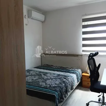 Furnished bedroom with a double bed, desk, and air conditioning. - image 9