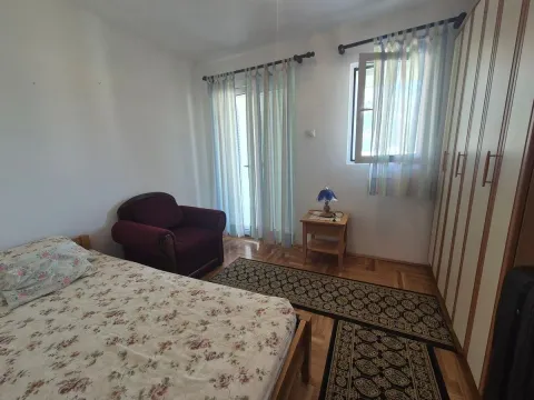 Furnished bedroom with a bed, armchair, and wardrobe. - image 6